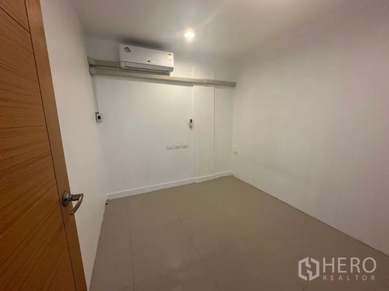 Home Office for rent in Bang Na, Bangkok - Compact air-conditioned room with tiled floor and white walls, ideal as a private office.
