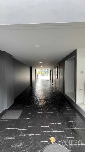 Home Office for rent - Covered ground-floor parking and entry passage with dark stone-style flooring.