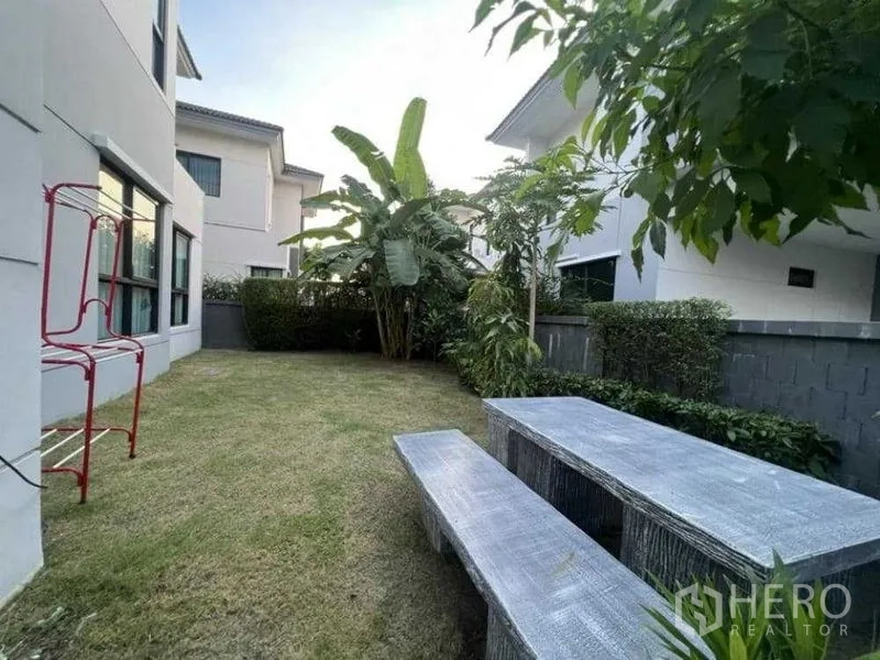 独立式住宅 出租在Mueang Nonthaburi, Nonthaburi - 私家庭院，草坪、热带植物与混凝土野餐桌。