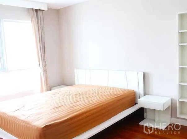 คอนโด ให้เช่าในHuai Khwang, Bangkok - ห้องนอนสว่าง เตียงกรอบสีขาว หน้าต่างบานใหญ่ โต๊ะข้างและชั้นวางของ