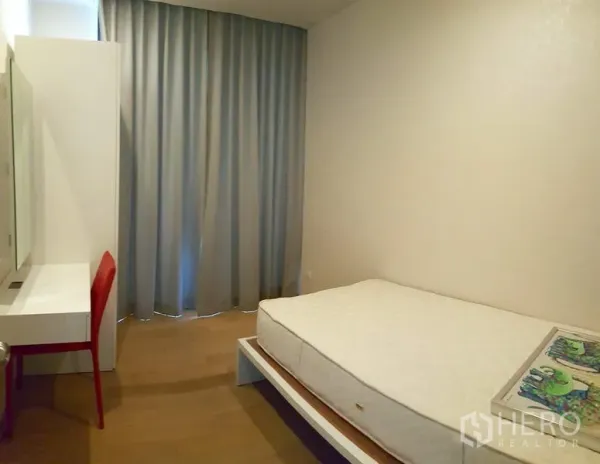 Condominium for rent in Phaya Thai, Bangkok - Second bedroom with single bed, built-in desk, mirror and full-height curtains.