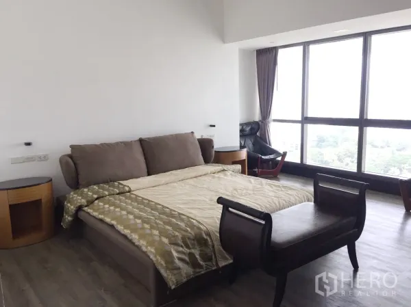 คอนโด ให้เช่าในWatthana, Bangkok - ห้องนอนกว้าง กระจกบานใหญ่ เก้าอี้เอนนอน มองเห็นวิวเมืองและพื้นที่สีเขียว