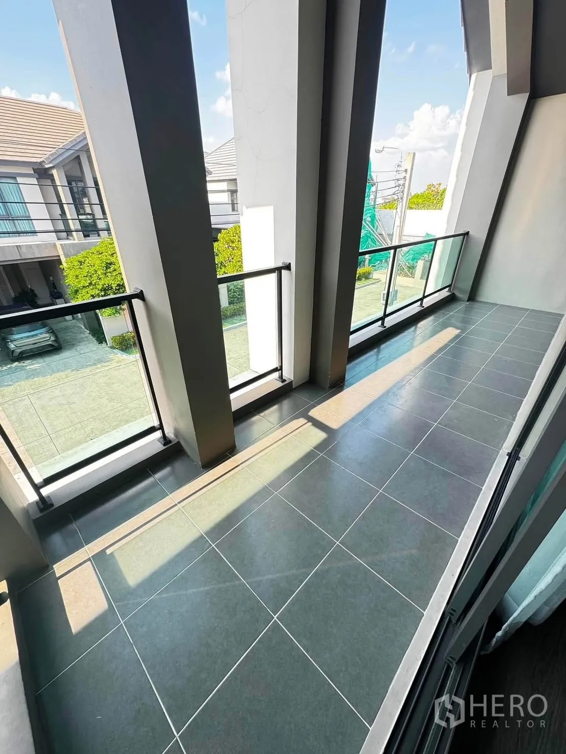 Detached House for rent in Saphan Sung, Bangkok - Upper-floor balcony with glass railings and tall columns overlooking a quiet street.