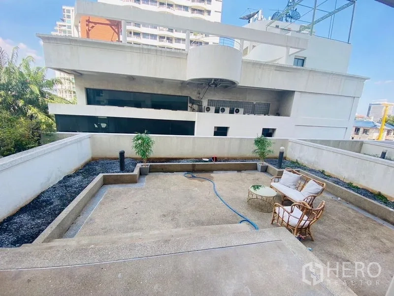 Condominium for rent or sale in Watthana, Bangkok - Private outdoor terrace patio with rattan seating and potted plants.