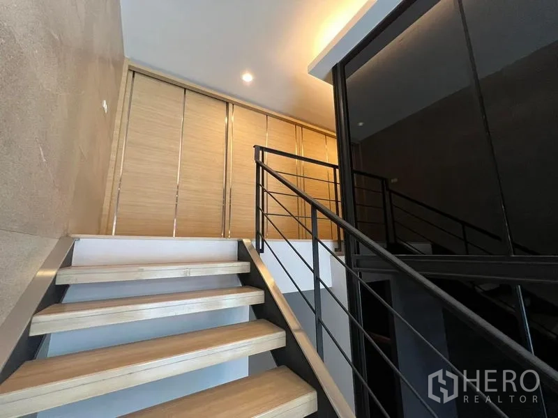 带办公室的家 出租在Bueng Kum, Bangkok - 楼梯通往二层，旁为黑色玻璃会议盒。