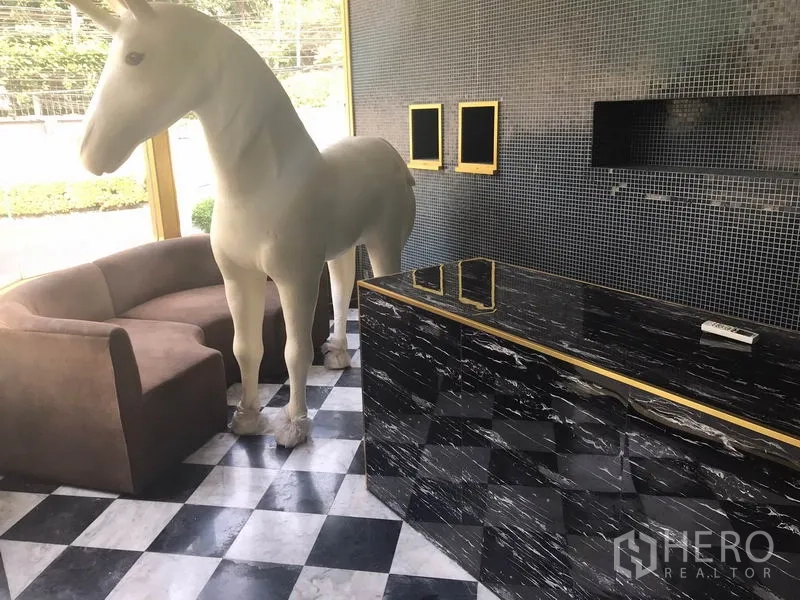 Retail Space for rent in Watthana, Bangkok - Interior with checkerboard flooring, sofa seating, and display-ready counter.