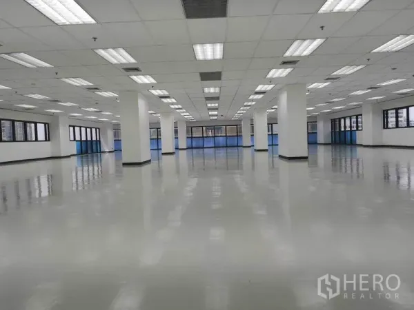 Office Space for rent in Phaya Thai, Bangkok - Large open‑plan office floor with glossy flooring, grid ceiling lights, white columns and wide perimeter windows.