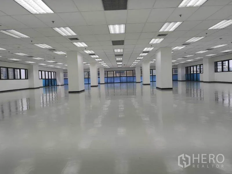 Office Space for rent in Phaya Thai, Bangkok - Large open‑plan office floor with glossy flooring, grid ceiling lights, white columns and wide perimeter windows.