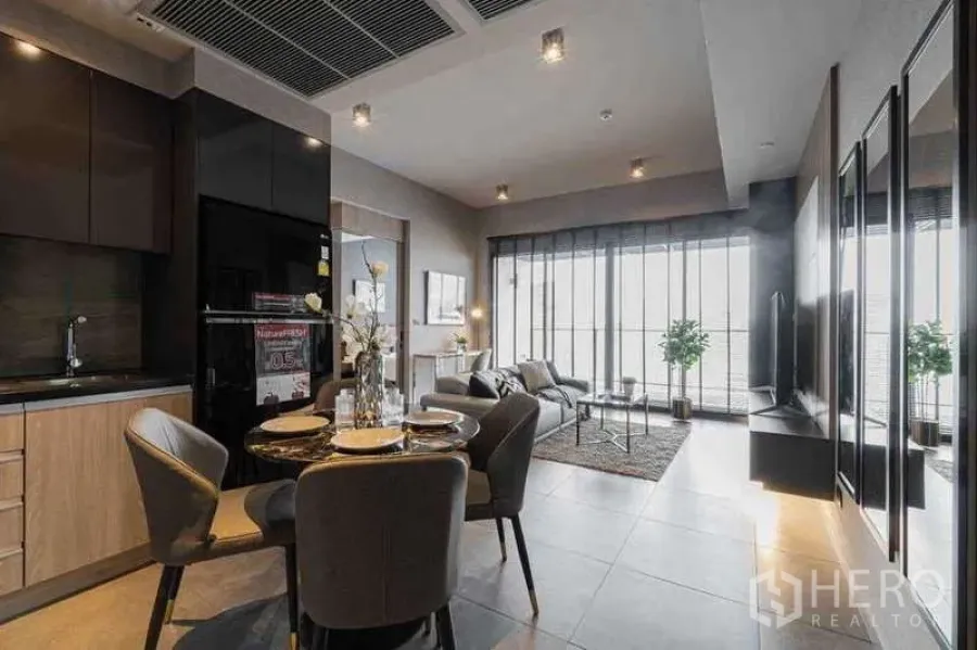 Condominium for rent in Watthana, Bangkok - Open-plan living with modern kitchen and marble dining set, floor-to-ceiling windows at The Lofts Asoke.