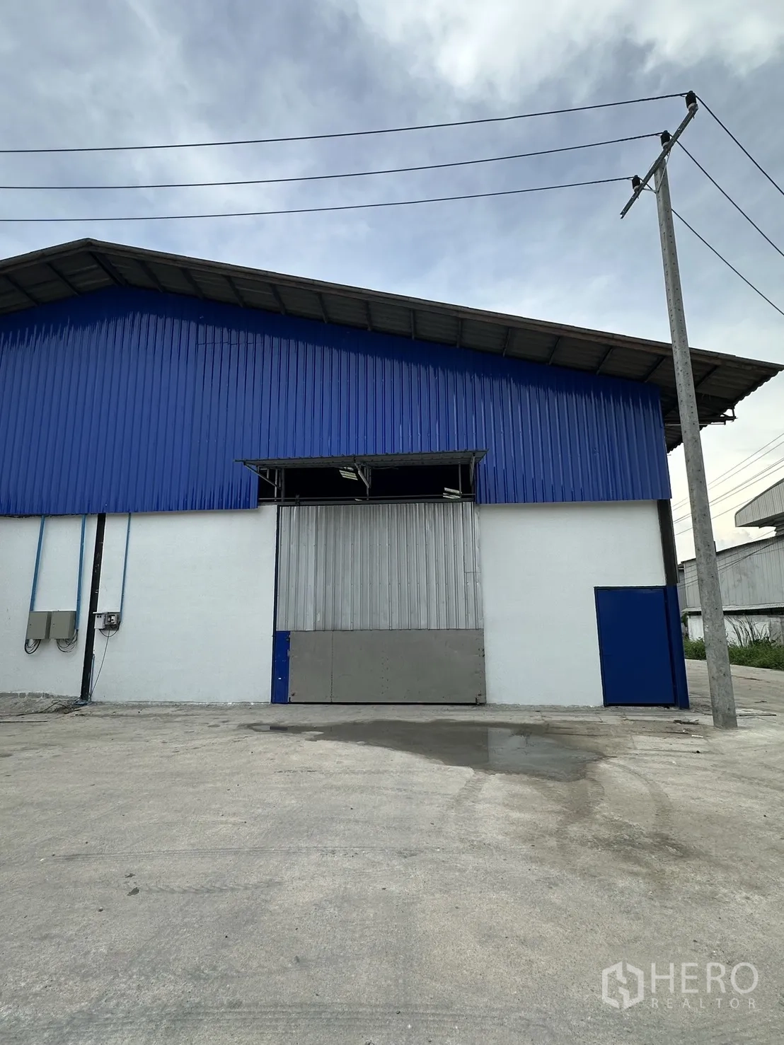 Warehouse for rent in Mueang Samut Prakan, Samut Prakan - Front elevation of the warehouse showing the main loading door and driveway.