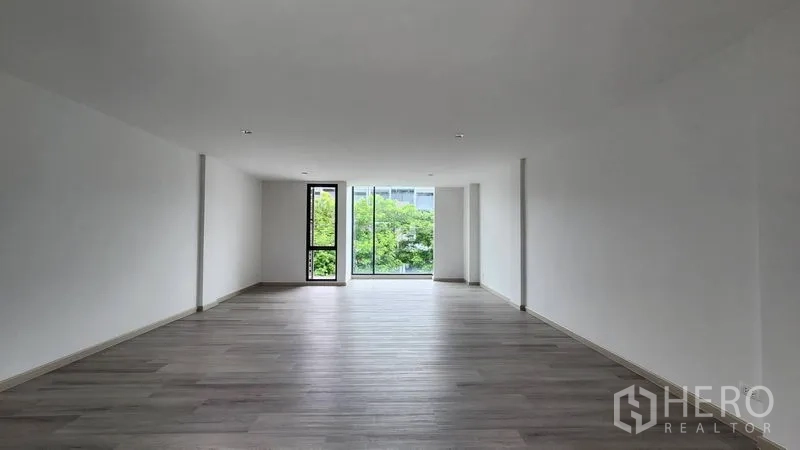 Home Office for rent - Bright open room facing a floor-to-ceiling window with leafy views.