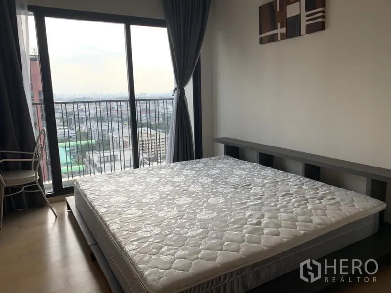 Condominium for rent in Phaya Thai, Bangkok - Bedroom with large window and balcony offering a wide Bangkok city skyline view.