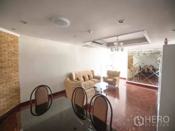 公寓 出租在Watthana, Bangkok - 明亮的客餐厅，拼花木地板、米色沙发、吊灯与镜面装饰墙。