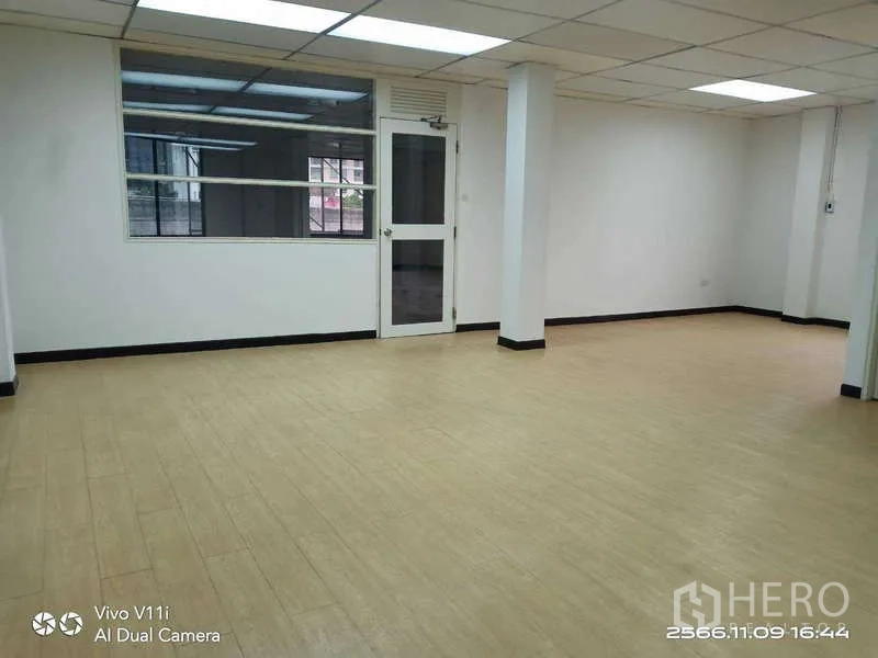 办公空间 出租在Bang Na, Bangkok - 明亮办公室，木纹地板、格栅吊顶灯与玻璃门。