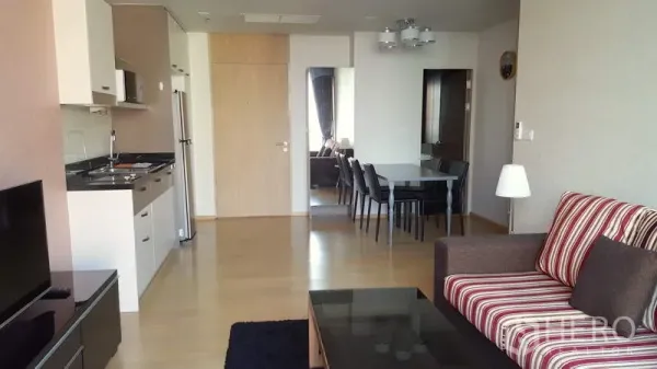 Condominium for rent in Phaya Thai, Bangkok - Open-plan living area showing fitted kitchen, fridge and four-seat dining next to the lounge.