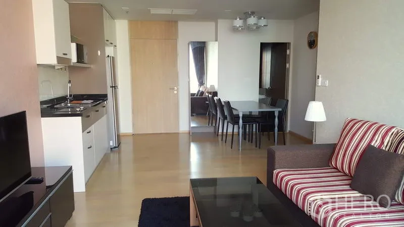Condominium for rent in Phaya Thai, Bangkok - Open-plan living area showing fitted kitchen, fridge and four-seat dining next to the lounge.