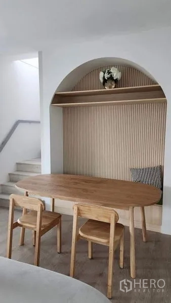 独立式住宅 出租 - 餐区，木质餐桌位于拱形内嵌置物架下方。
