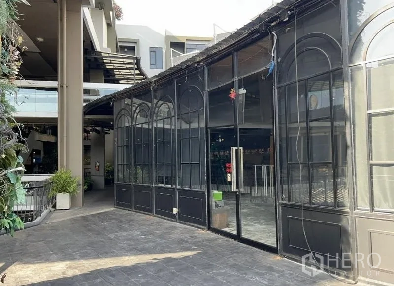 Retail Space for rent - Main entrance featuring tall glass doors and arched windows beside the mall atrium.