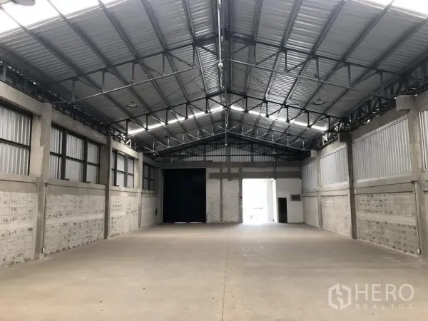Factory for rent in Khlong Luang, Pathum Thani - Spacious warehouse interior facing the loading bay and office entrance.