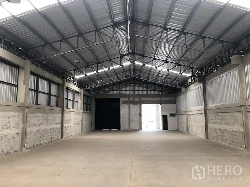 Factory for rent in Khlong Luang, Pathum Thani - Spacious warehouse interior facing the loading bay and office entrance.