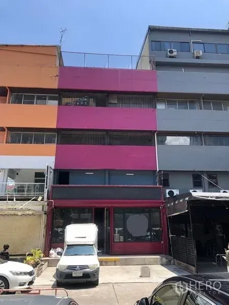 店屋 出租在Watthana, Bangkok - 四层临街商铺外观，亮桃红立面，门前可停车，位于艾卡迈区域。