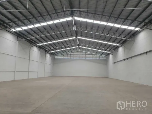货栈 出租在Khlong Luang, Pathum Thani - 宽敞仓库内部，高钢结构屋顶带天窗，光滑混凝土地面。