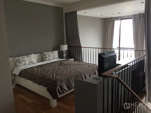 公寓 出租在Khlong Toei, Bangkok - 阁楼式卧室，特大床与栏杆，俯瞰客厅