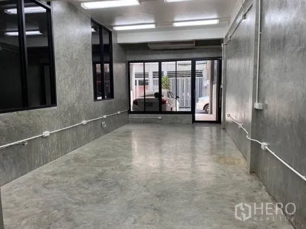 带办公室的家 出租在Bang Rak, Bangkok - 一层开放式工作区，清水混凝土墙面、玻璃门面与充足照明。