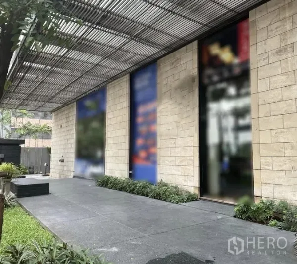 Retail Space for rent - Modern stone-clad shopfront on Sukhumvit with tall glazed panels, wide covered walkway and landscaped frontage.