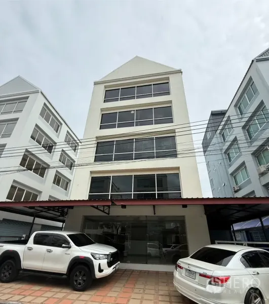 办公空间 出租在Bueng Kum, Bangkok - 多层办公楼正立面，带前方车位与玻璃入口。