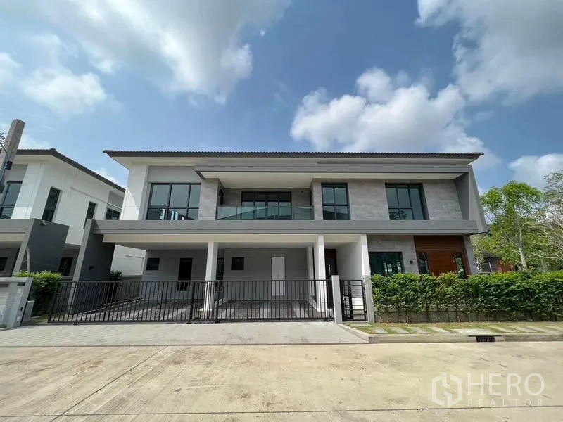 Detached House for rent - Front elevation of contemporary detached house with balcony and covered double carport.
