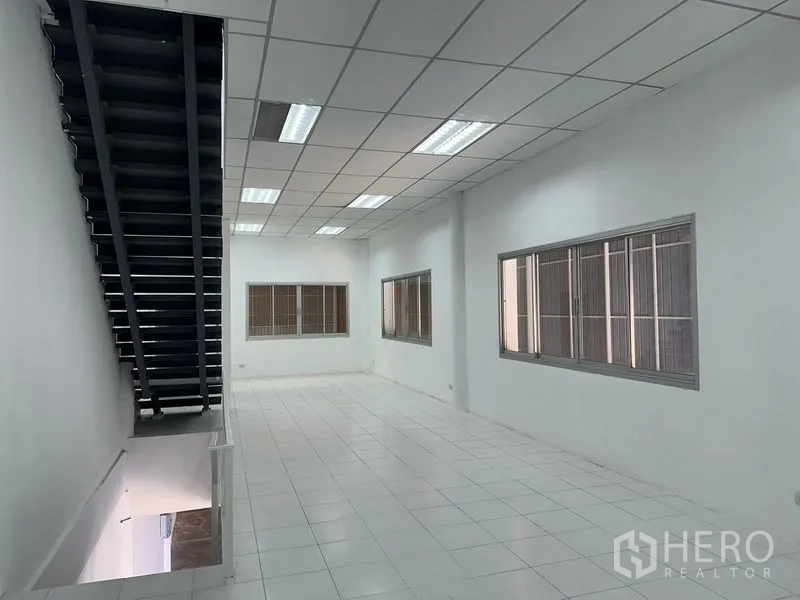 Factory for rent in Khlong Luang, Pathum Thani - Spacious mezzanine office with tiled flooring, fluorescent lighting, and multiple windows.