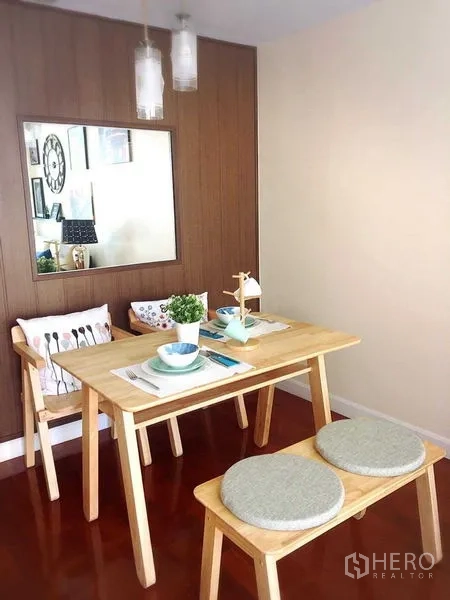 Condominium for rent in Khlong Toei, Bangkok - Compact dining nook with wooden table, bench seating, and pendant lights.