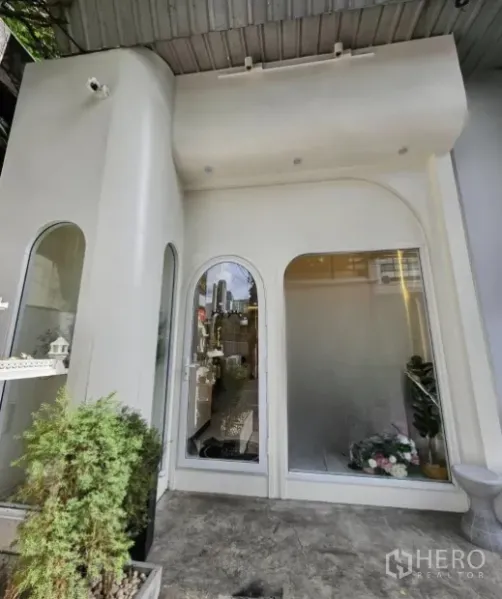 Retail Space for rent in Watthana, Bangkok - Street-facing white retail facade with arched glass windows and planter.