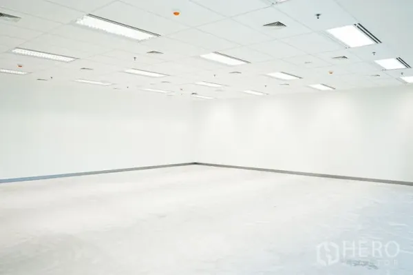 办公空间 出租在Bang Na, Bangkok - 空置办公室一角，白色墙面、吊顶通风口与日光灯，适合自由装修