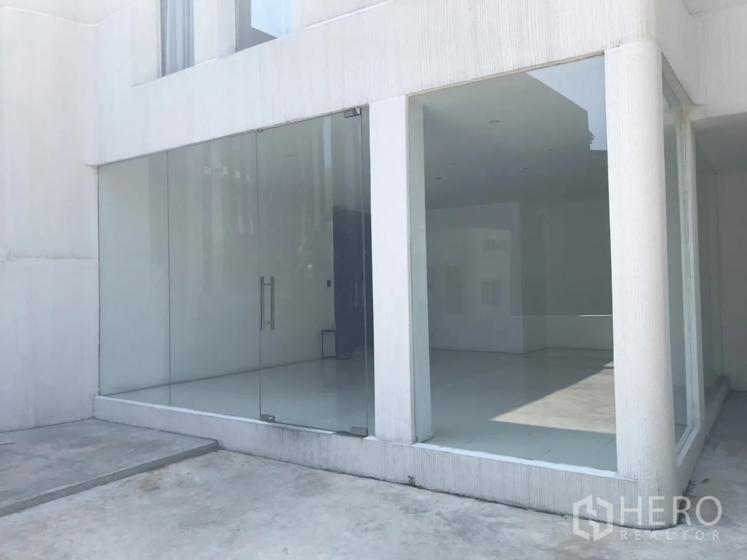 Retail Space for rent in Khlong Toei, Bangkok - Street-facing glass storefront with double doors and a bright white exterior.