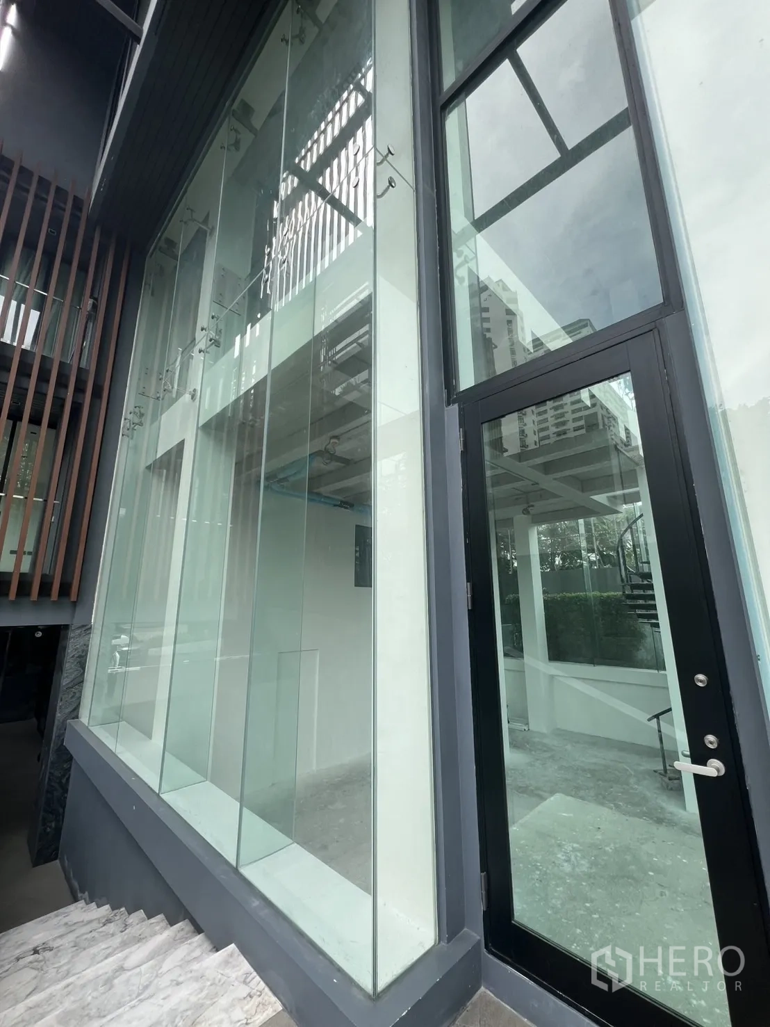 Retail Space for rent - Close view of entrance door and frameless glass storefront.