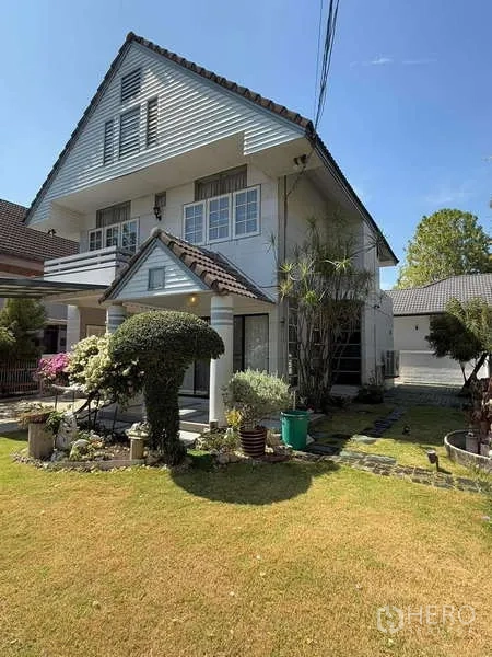 独立式住宅 出租在Bang Kapi, Bangkok - 侧院草坪与高耸人字顶外立面，园林景观整洁。