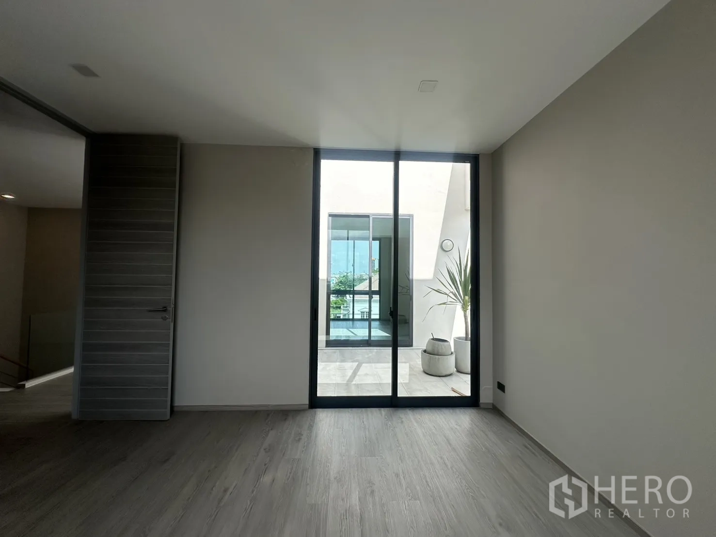 家庭办公室 for rent or sale in Suan Luang, Bangkok - 卧室或办公室面向明亮露台与盆栽。