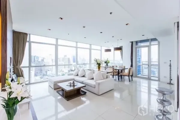 公寓 出租在Pathum Wan, Bangkok - 另一个角度的客厅，L 型沙发、大窗与阳台门。