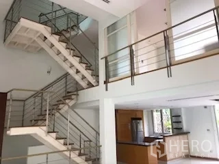 Townhouse for rent or sale in Yan Nawa, Bangkok - Modern staircase with metal rails connecting mezzanine levels above the kitchen.