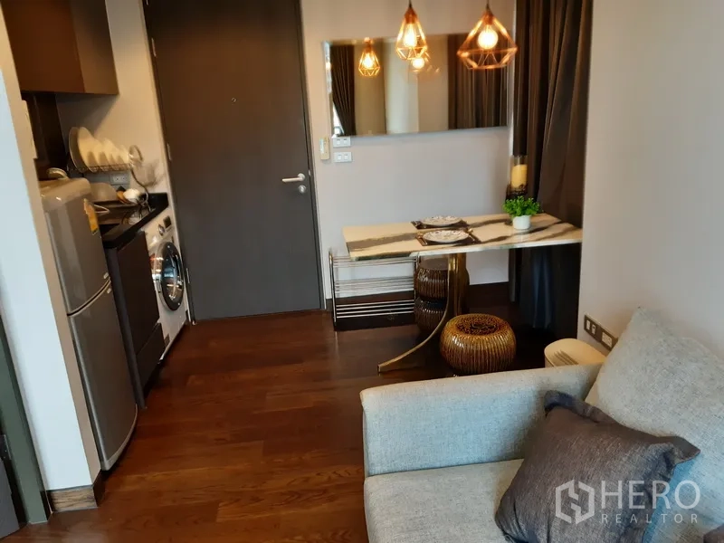 Condominium for rent or sale in Khlong Toei, Bangkok - Open kitchenette with fridge and washing machine, marble dining table and pendant lights.