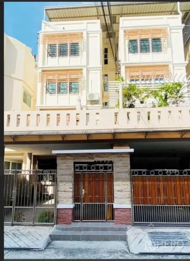 Townhouse for sale in Phra Khanong, Bangkok - Multi-storey townhouse facade with gated entrance, balconies, and sunshades.