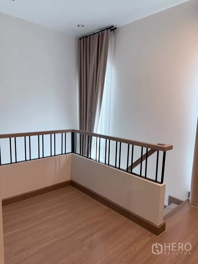 Detached House for rent in Lat Krabang, Bangkok - Upstairs landing with wooden flooring and metal balustrade.