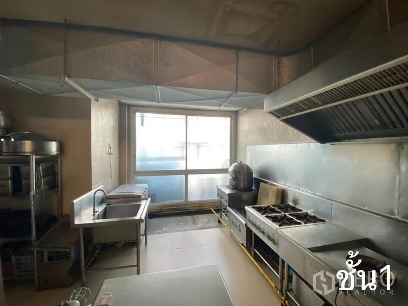 Shophouse for rent in Watthana, Bangkok - Commercial kitchen with stainless counters, gas stoves and extractor hood.