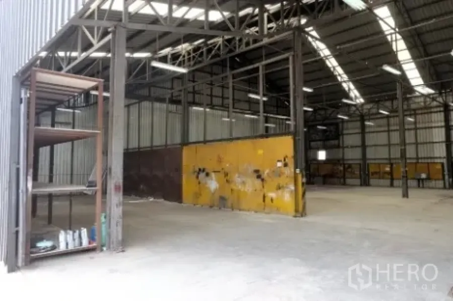 คลังสินค้า ให้เช่าในPak Kret, Nonthaburi - มุมมองทางเข้าโกดังพร้อมชั้นเหล็กและผนังกั้นสีเหลือง