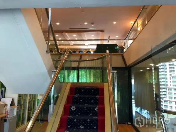 Office Space for rent in Bang Na, Bangkok - View up the carpeted staircase to the mezzanine, framed by glass balustrades.