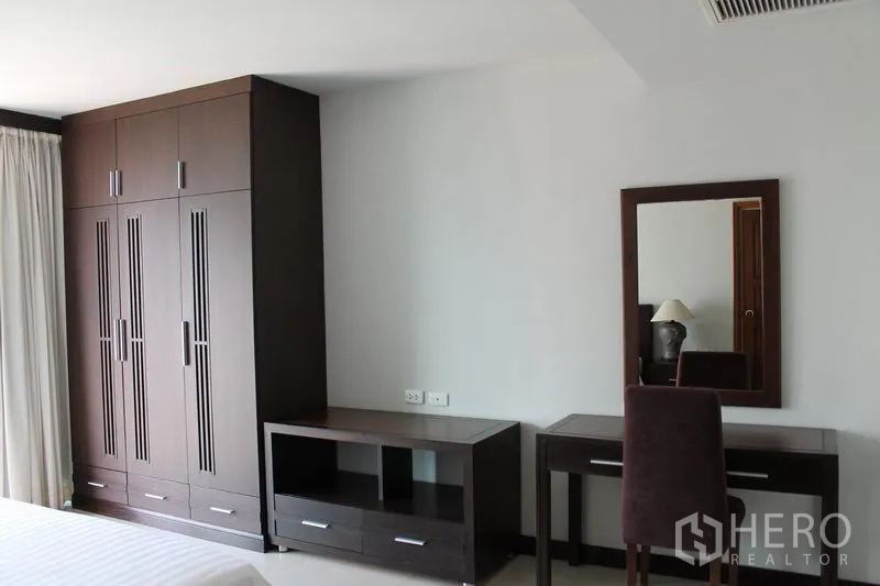 Apartment for rent in Bang Rak, Bangkok - Built-in wardrobe, TV console and dressing table in the bedroom.