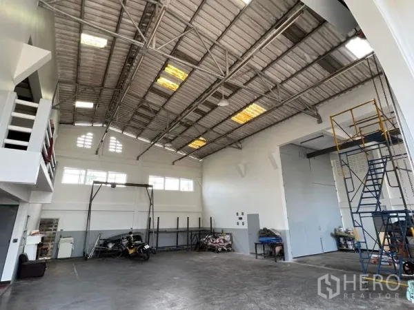 货栈 出租在Thung Khru, Bangkok - 明亮仓库大厅，采光板、通风窗、储物架与钢桁架屋顶。
