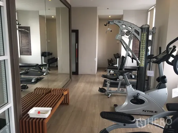 Condominium for rent in Phaya Thai, Bangkok - Condominium fitness room with cardio machines, free weights, mirrors and light wood flooring.
